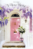 This Collier Row entrance is captured at a moment that feels both calm and full of possibility, with floral details carefully chosen to honour a new beginning. The focal point is a beautifully painted pink front door, finished in a soft, blush tone that glows gently against the clean white of the surrounding walls. The paint appears newly applied yet welcoming, its pastel hue echoing the gentle character of the residential streets that branch off Collier Row Road. A single matching shutter rests beside it, quietly mirroring the colour and adding a balanced, composed rhythm to the façade. Draped overhead, wisteria falls in cascading strands of lavender and lilac, the vines woven in loose, natural arcs. Each hanging cluster of blossoms adds to a billowing curtain of purple, suggesting a drifting, powdery scent that would greet anyone standing on the step. At the base of the doorway, a sturdy grey bucket sits neatly centred, brimming with creamy white roses that are fully unfurled, revealing layer upon layer of soft petals. Small sprigs of fresh green foliage nestle between the blooms, adding depth and a hint of woodland freshness as they spill gently over the rim. Encircling the bucket is a soft pink ribbon, tied into a simple bow whose ends lie across the stone step like brushstrokes, perfectly in tune with the door's colour. Subtle, golden-tinged light slides across the scene, catching the edges of petals and leaves and giving the composition a warm, anticipatory glow. It feels like a new home bouquet delivered with care by a local Collier Row florist, a floral gesture left at the threshold to say welcome, congratulations, and may this house be filled with joy.